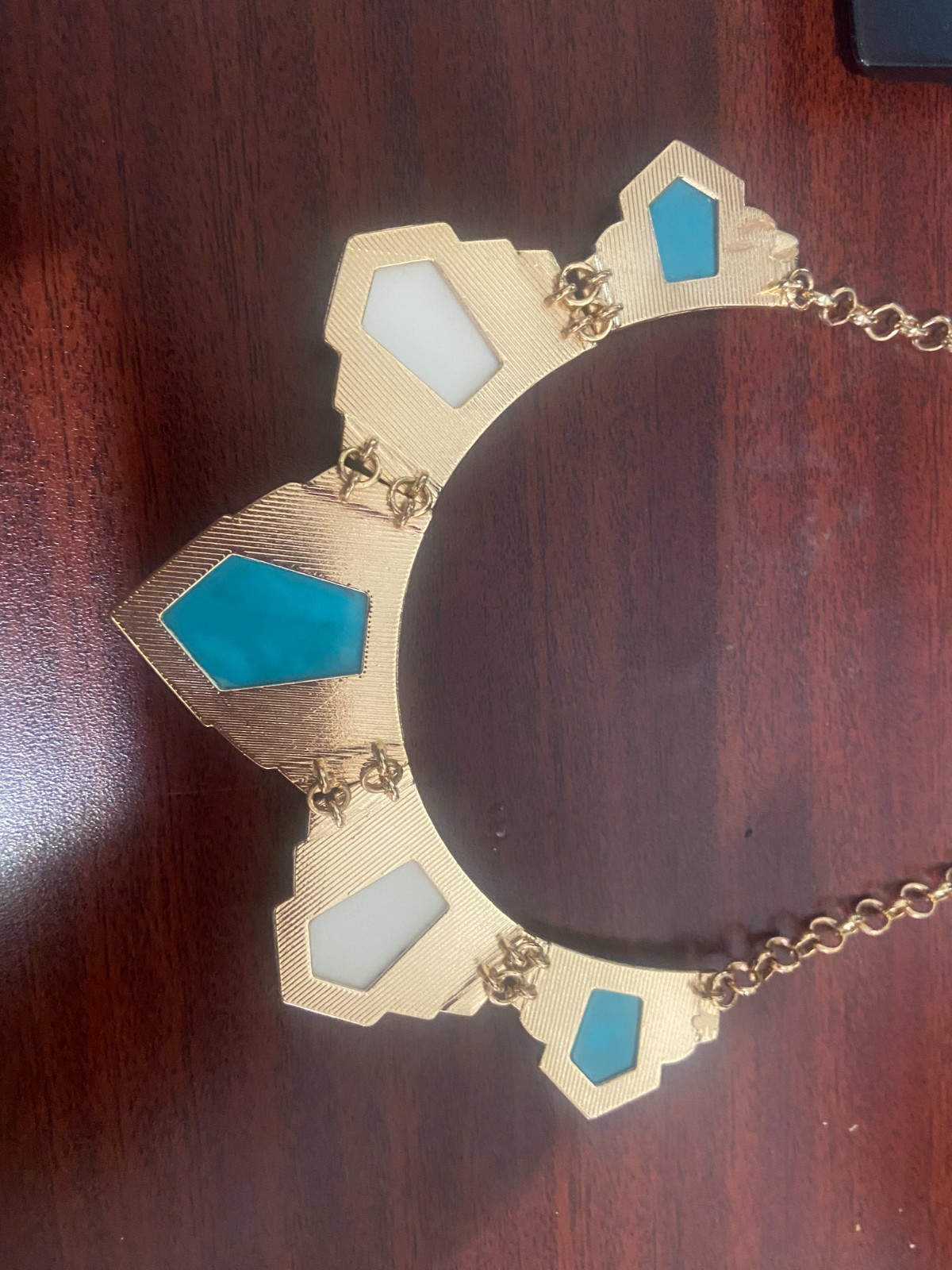 Gold chained necklace with cyan, white and oak brown gemstones.