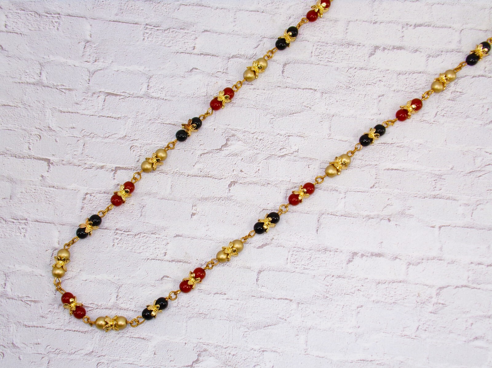 Multi color glass bead necklace with a mix of red, black, and gold colors New