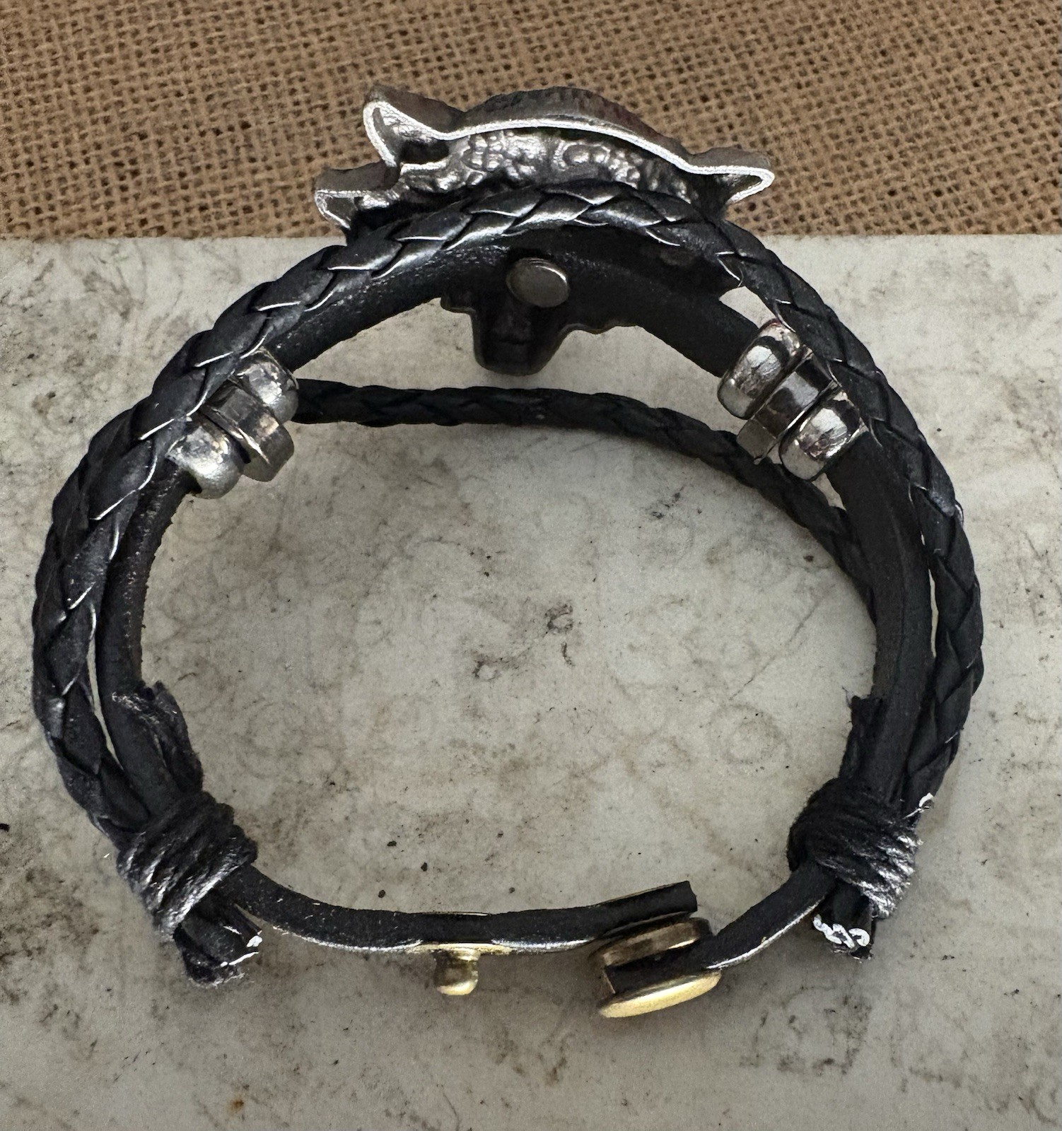black braided leather bracelet . silver metal wolf head charm . adjustable snap