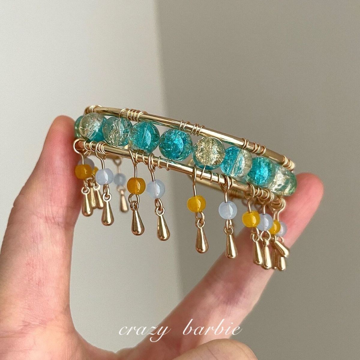 Green beaded bracelet with metal tassels
