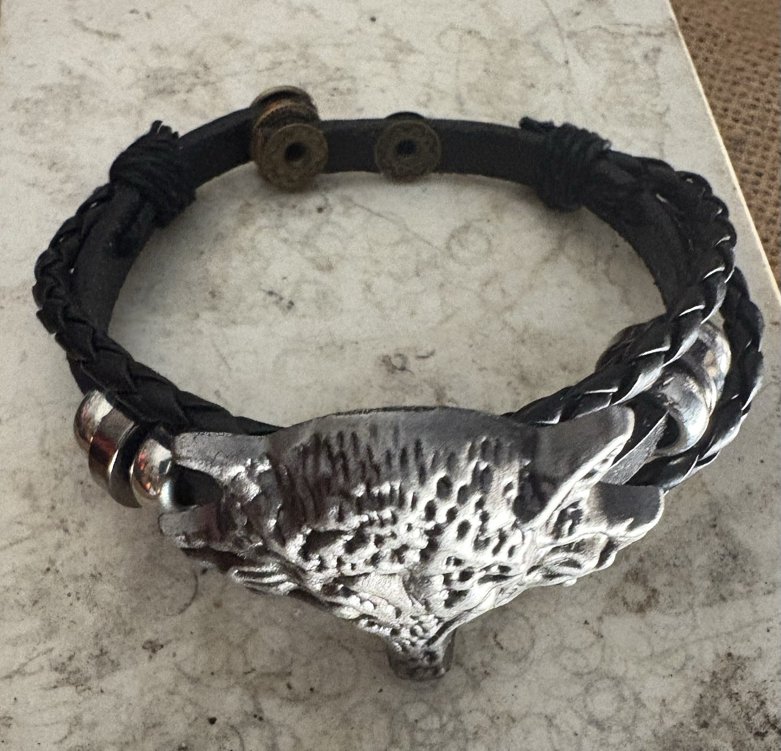black braided leather bracelet . silver metal wolf head charm . adjustable snap