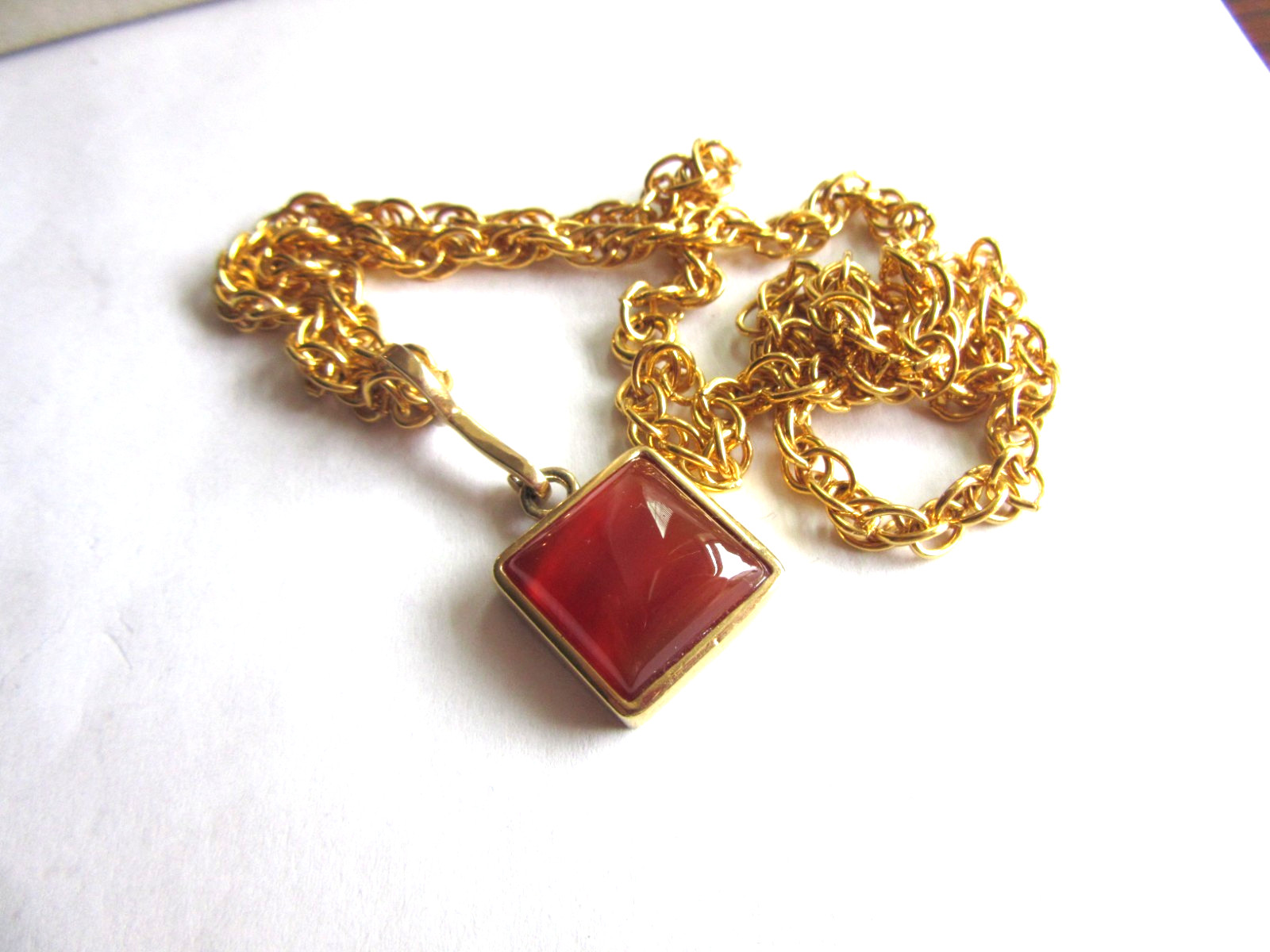 Gold tone rope chain necklace with Roman brand carnelian pendant