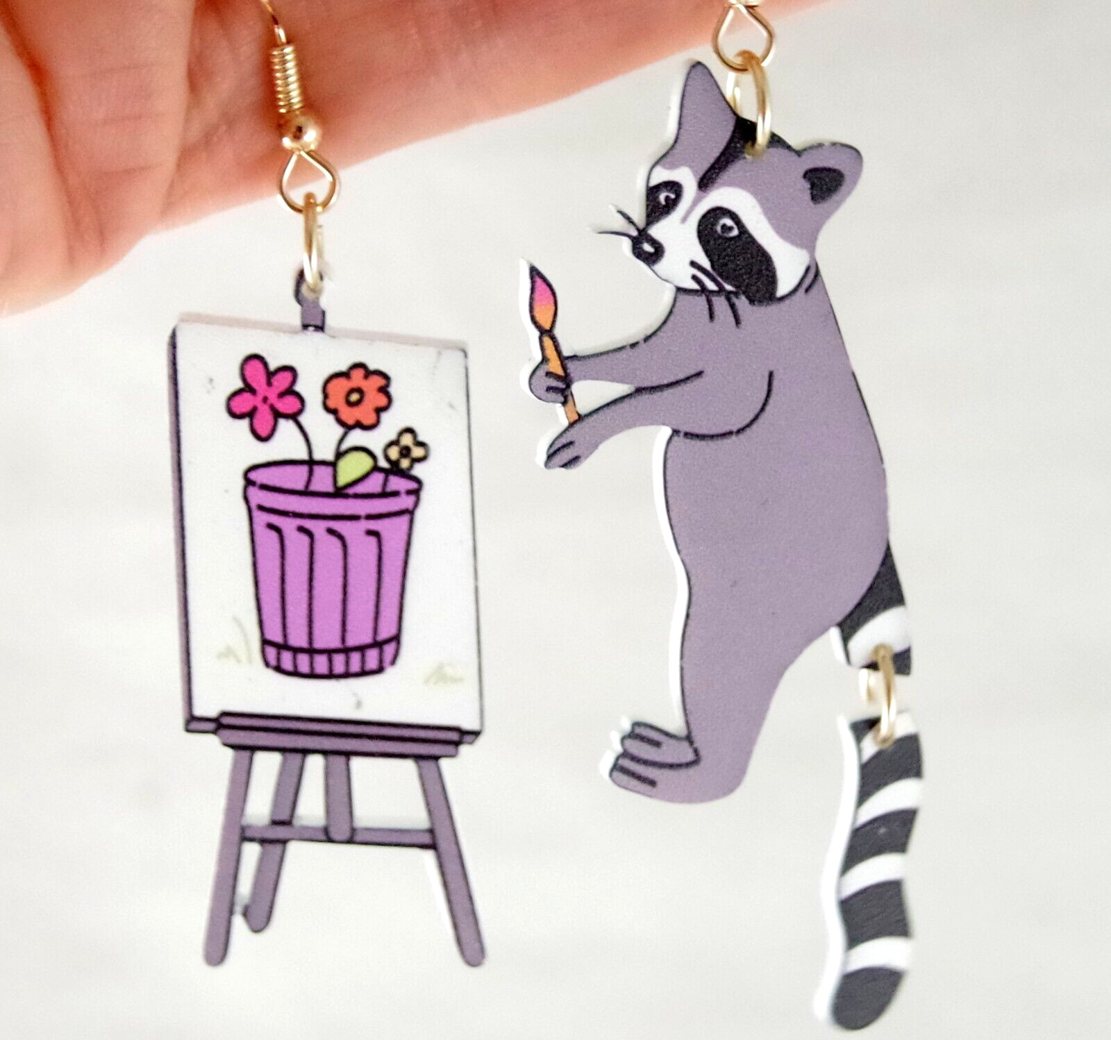 ASYMMETRICAL RACOON ARTIST PAINTING FLOWERS IN GARBAGE CAN ACRYLIC DROP EARRINGS
