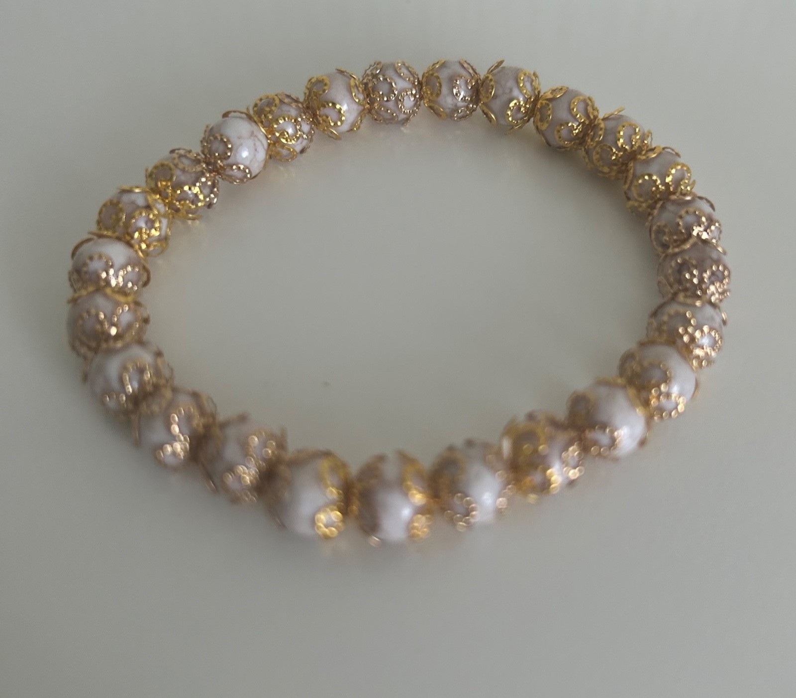 Ladies beautiful bracelet, with beige beads and gold coloured covered detail S/M