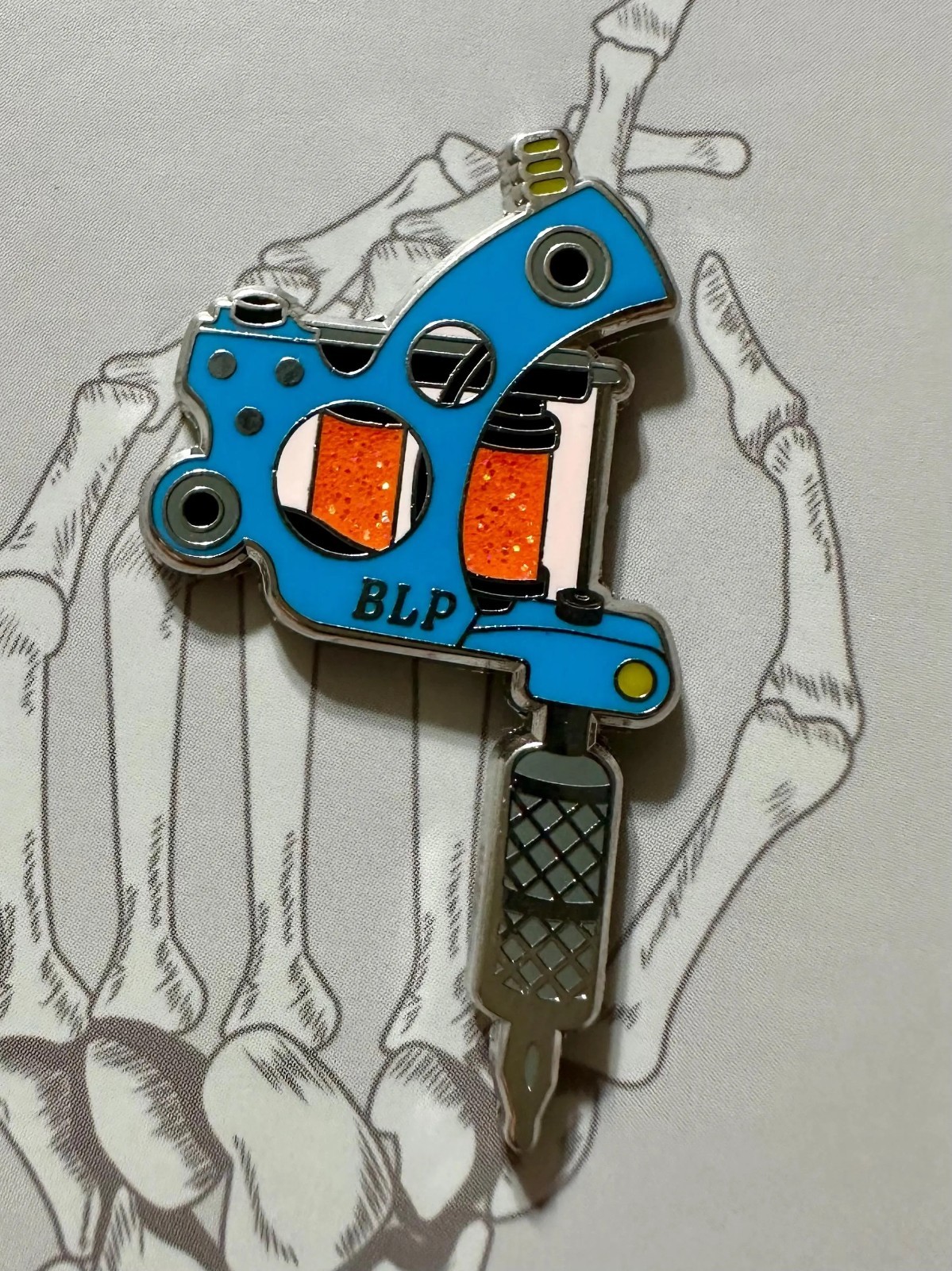 Tattoo Machine Enamel Pin – Blue with Orange Glitter