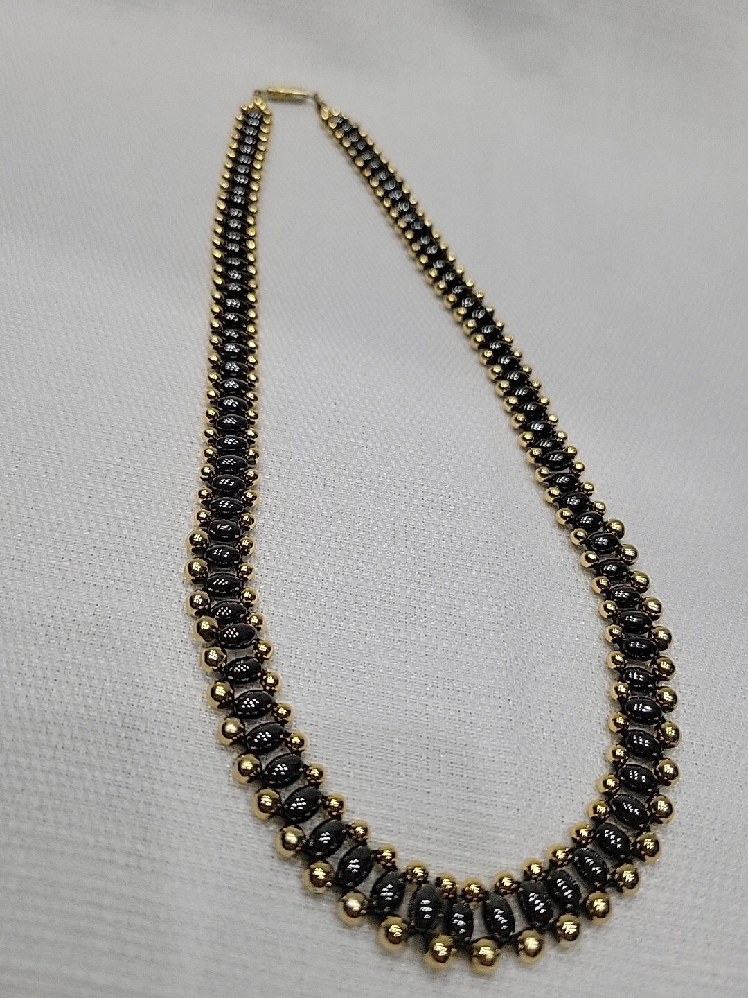 Gold toned and black toned round and oblong beaded necklace