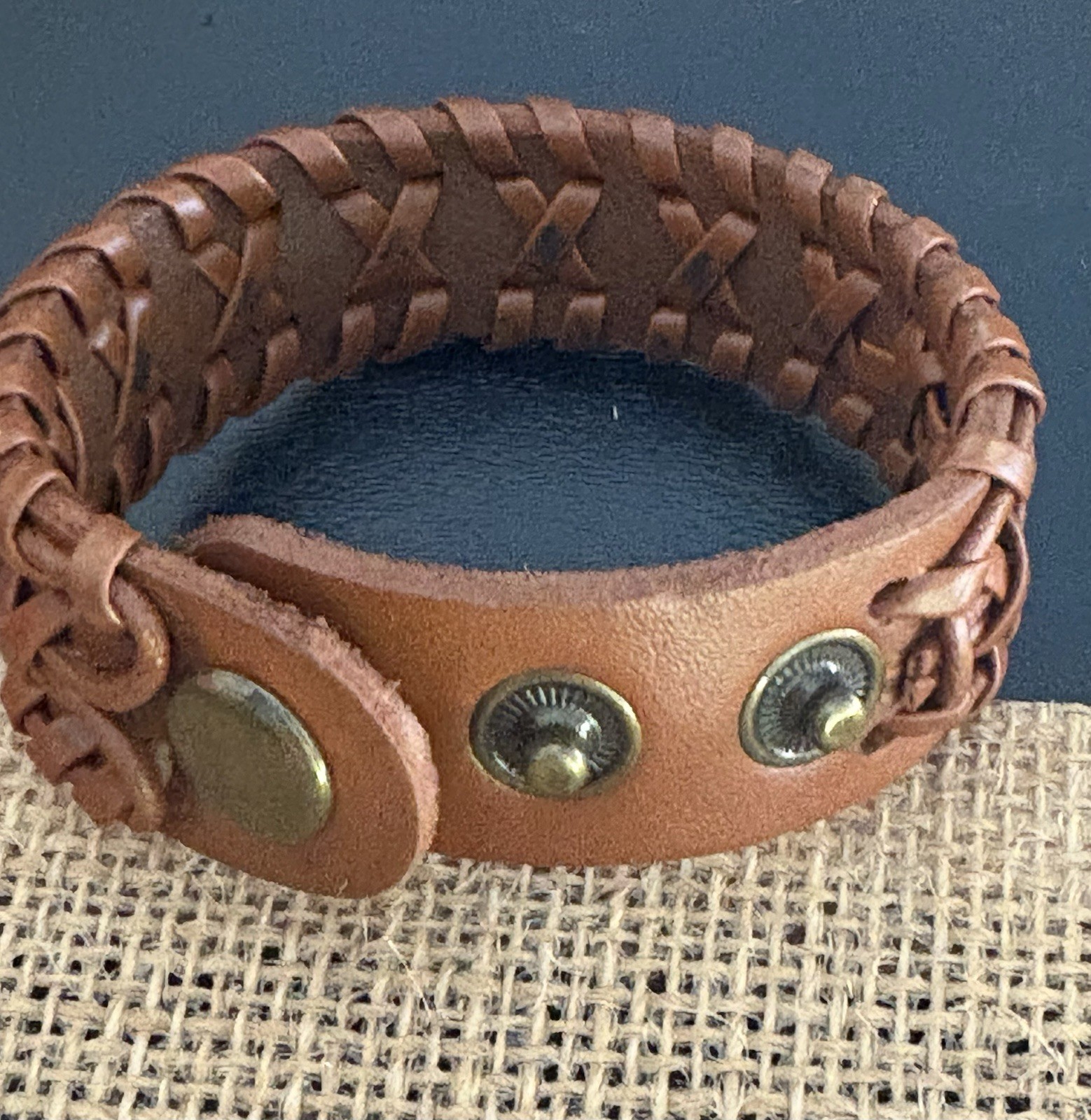 brown braided leather cuff bracelet . snap closure . adjustable 8 in . no stone