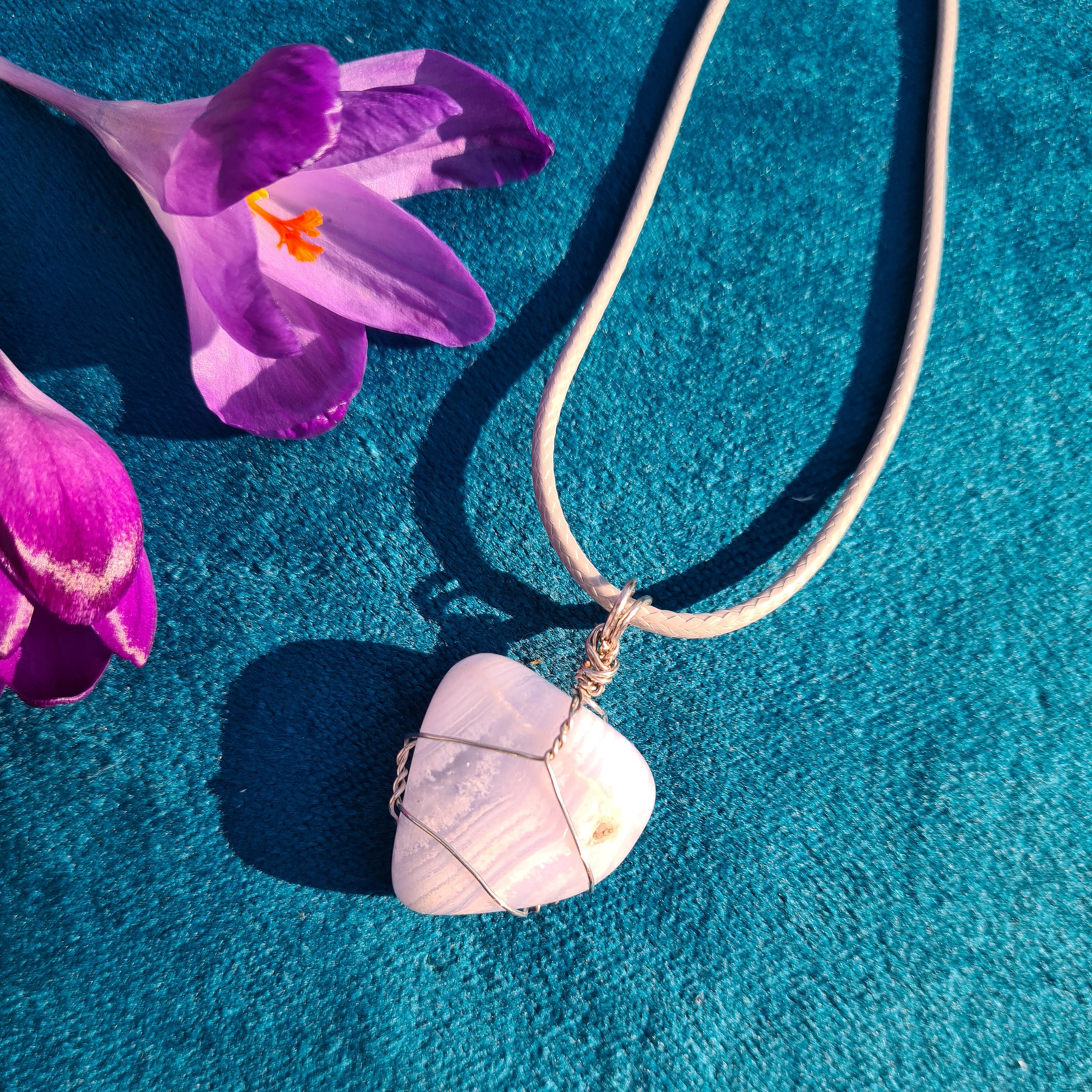 Blue lace agate wrapped pendant on a cream cord