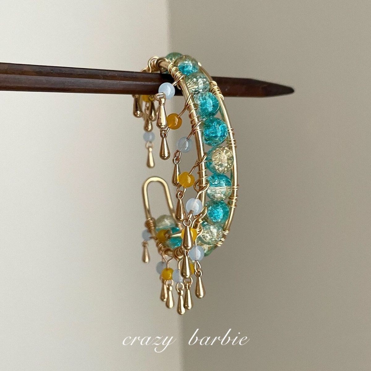 Green beaded bracelet with metal tassels