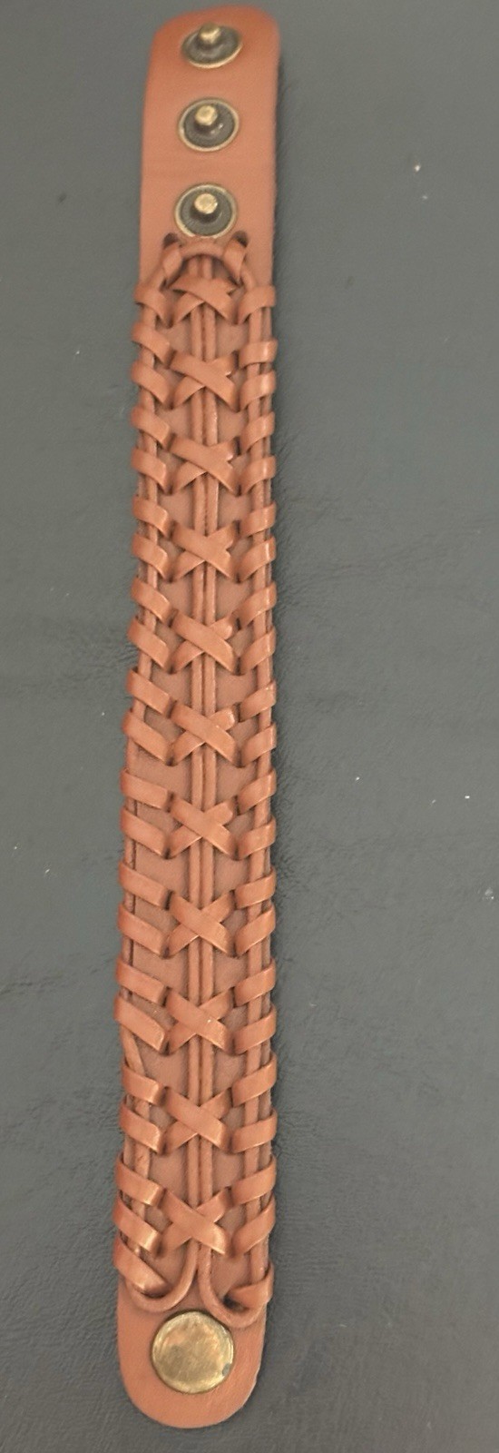 brown braided leather cuff bracelet . snap closure . adjustable 8 in . no stone