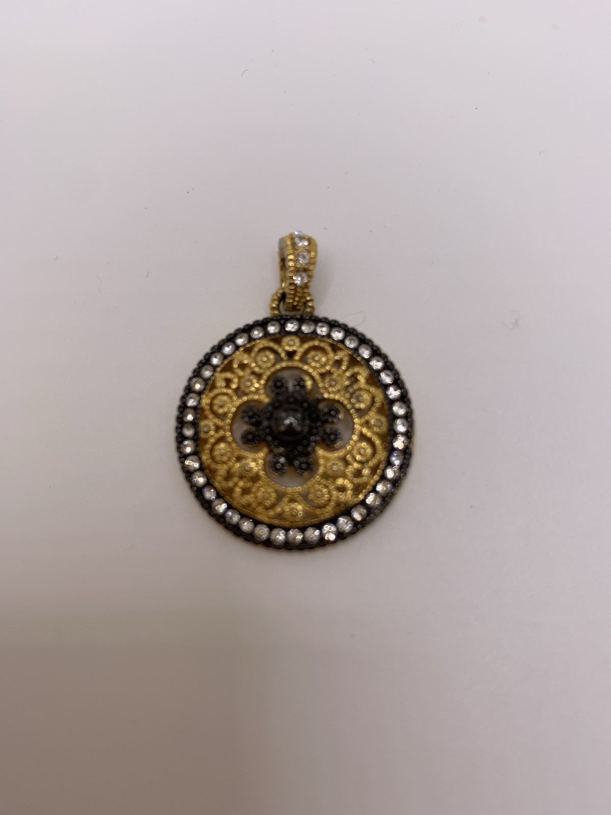 Round gold tone filigree pendant/ black quatrefoil motif & a halo of clear stone