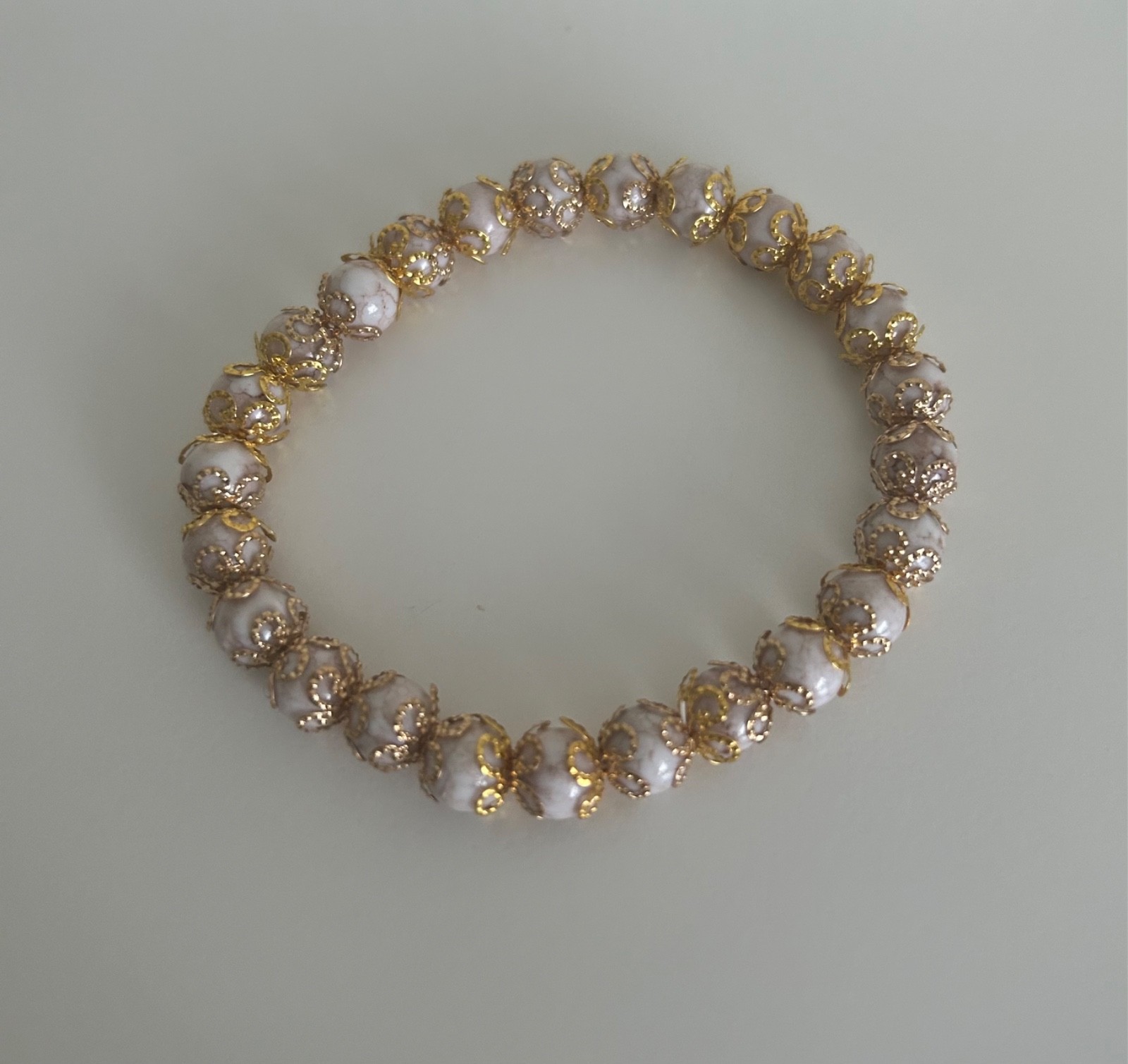 Ladies beautiful bracelet, with beige beads and gold coloured covered detail S/M