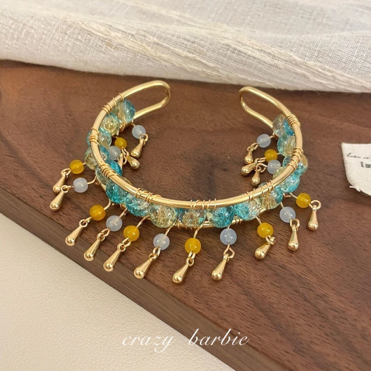 Green beaded bracelet with metal tassels
