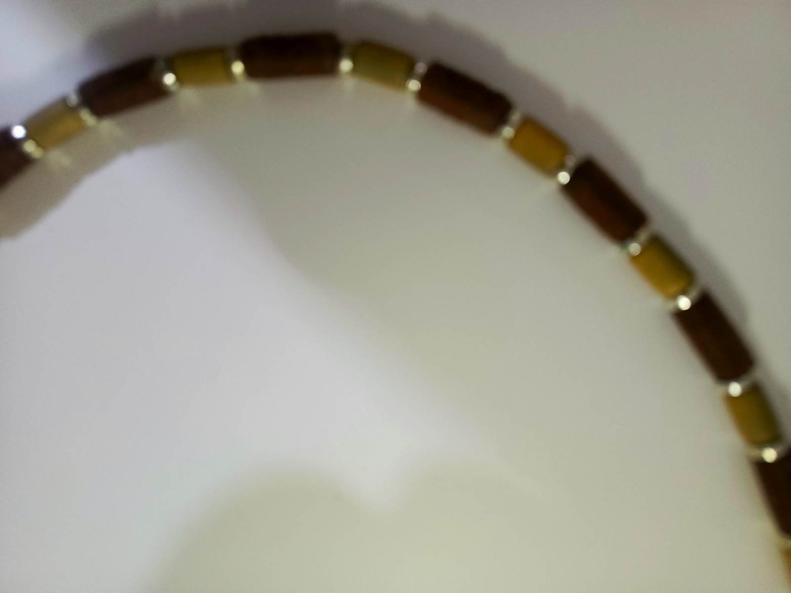 necklace features Polaris barrels in brown and beige separated by small gold-col