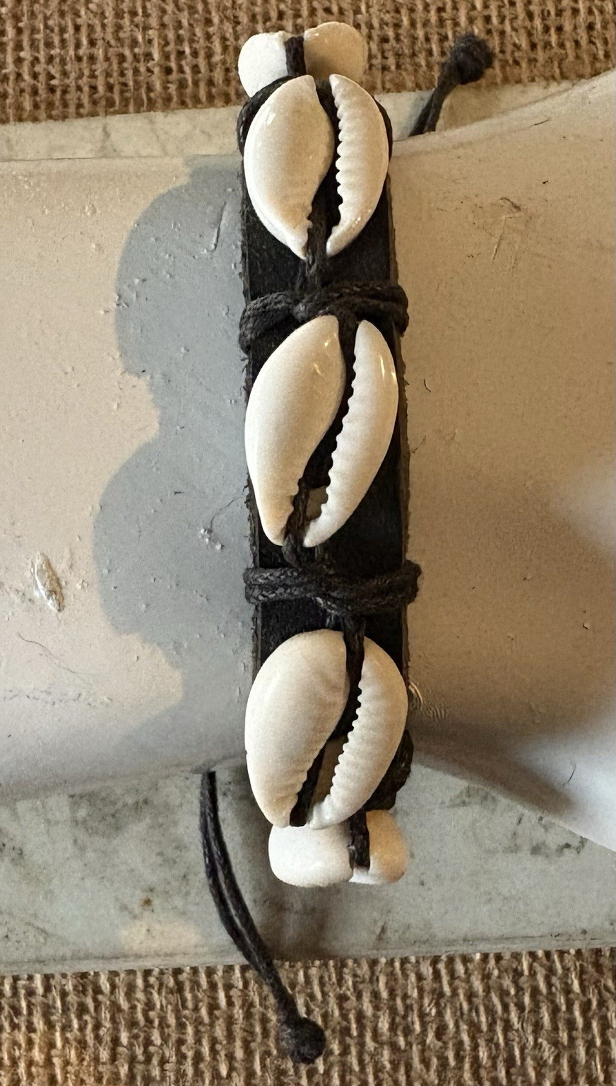 black cord cuff bracelet . white cowrie shell . adjustable tie closure . beach