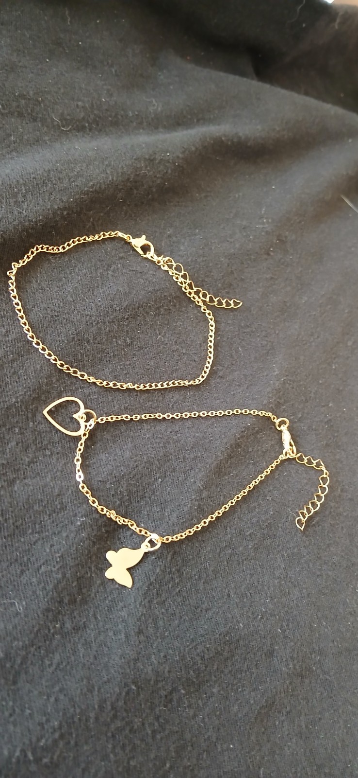 A Set of 2 Anklets, 1 gold tone Chain and 1 with 2 charms on a gold tone chain