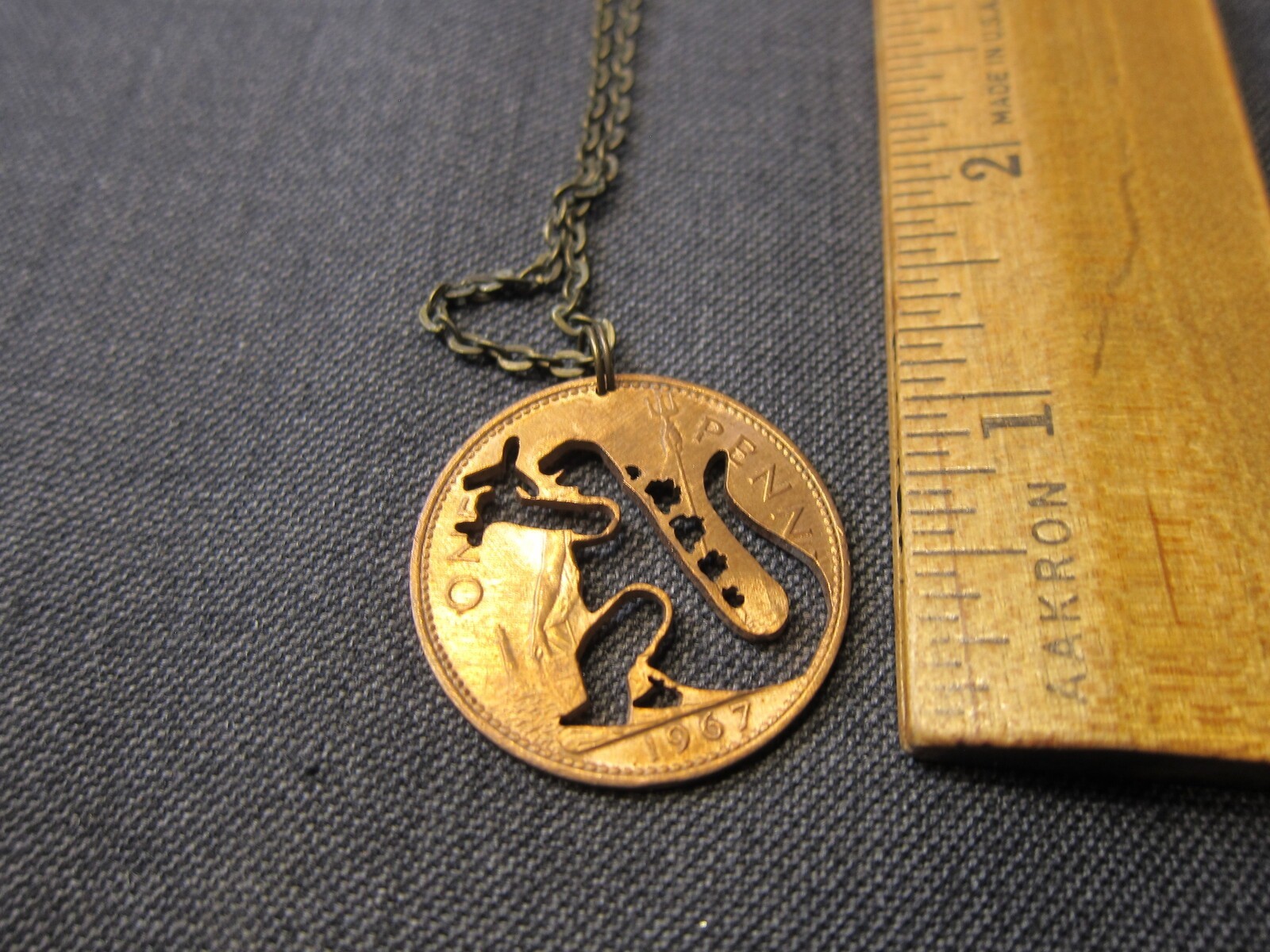 Cute 1967 British penny coin cutout necklace Godzilla grabbing airplane!