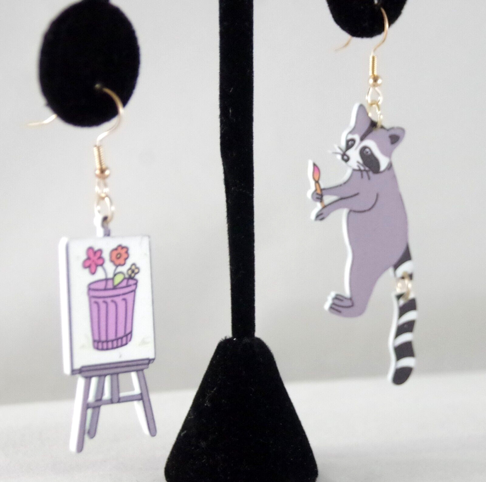 ASYMMETRICAL RACOON ARTIST PAINTING FLOWERS IN GARBAGE CAN ACRYLIC DROP EARRINGS