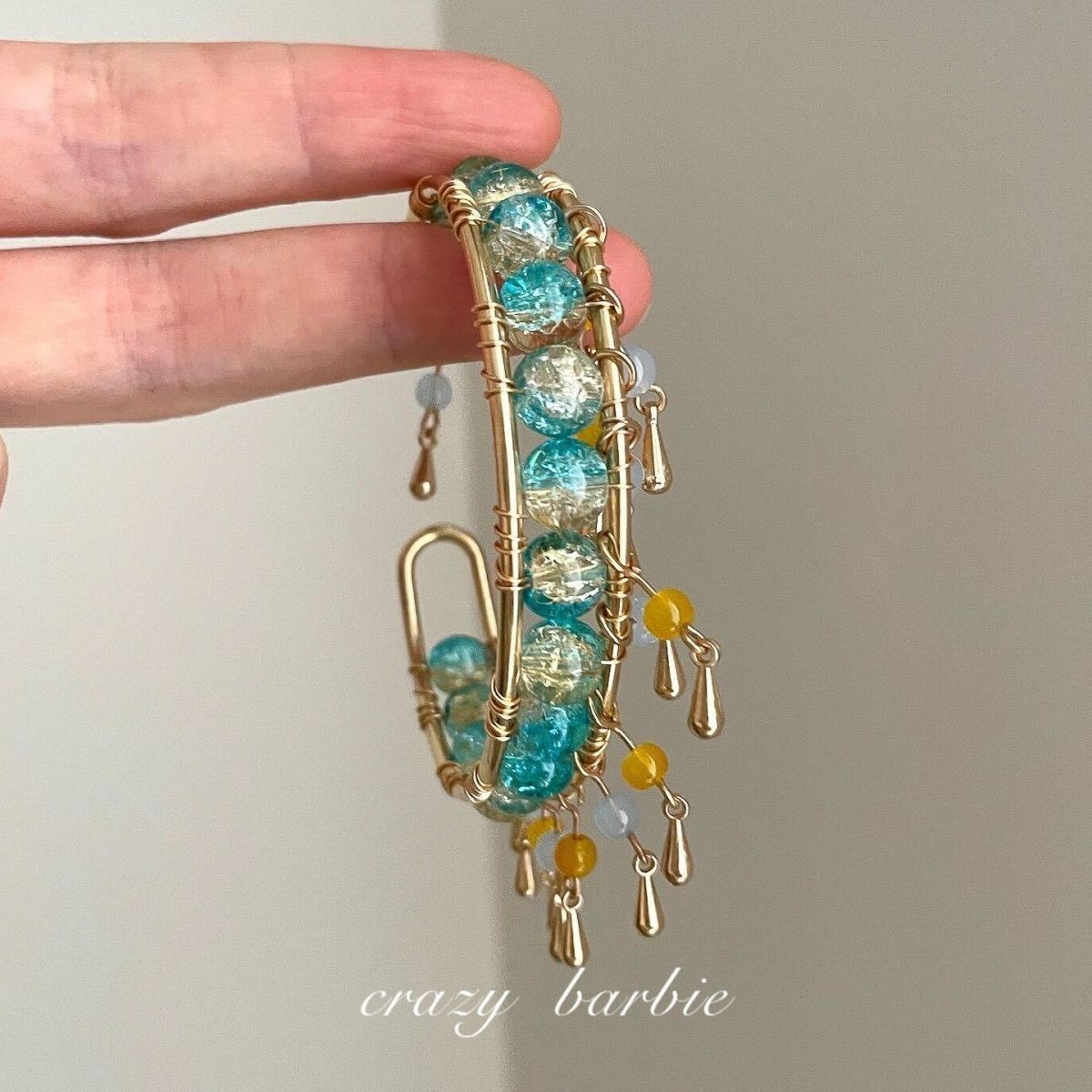 Green beaded bracelet with metal tassels
