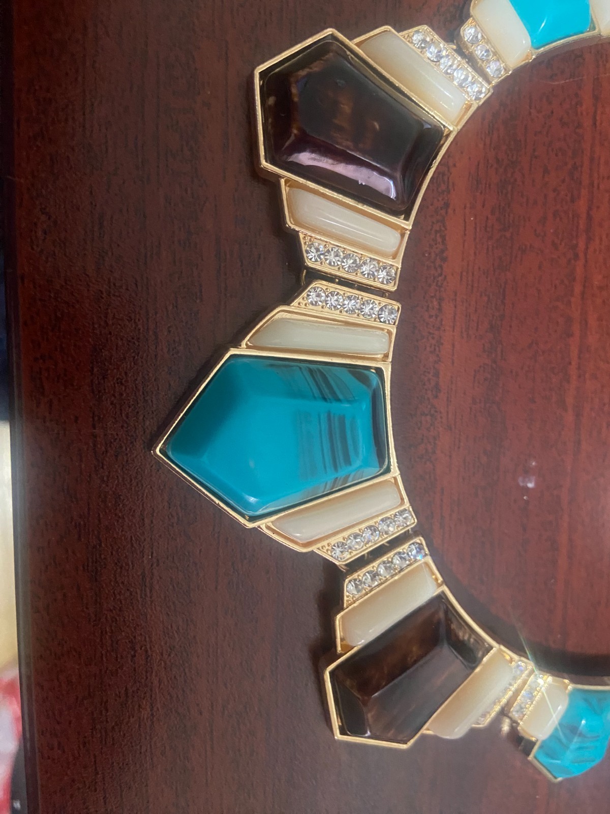 Gold chained necklace with cyan, white and oak brown gemstones.