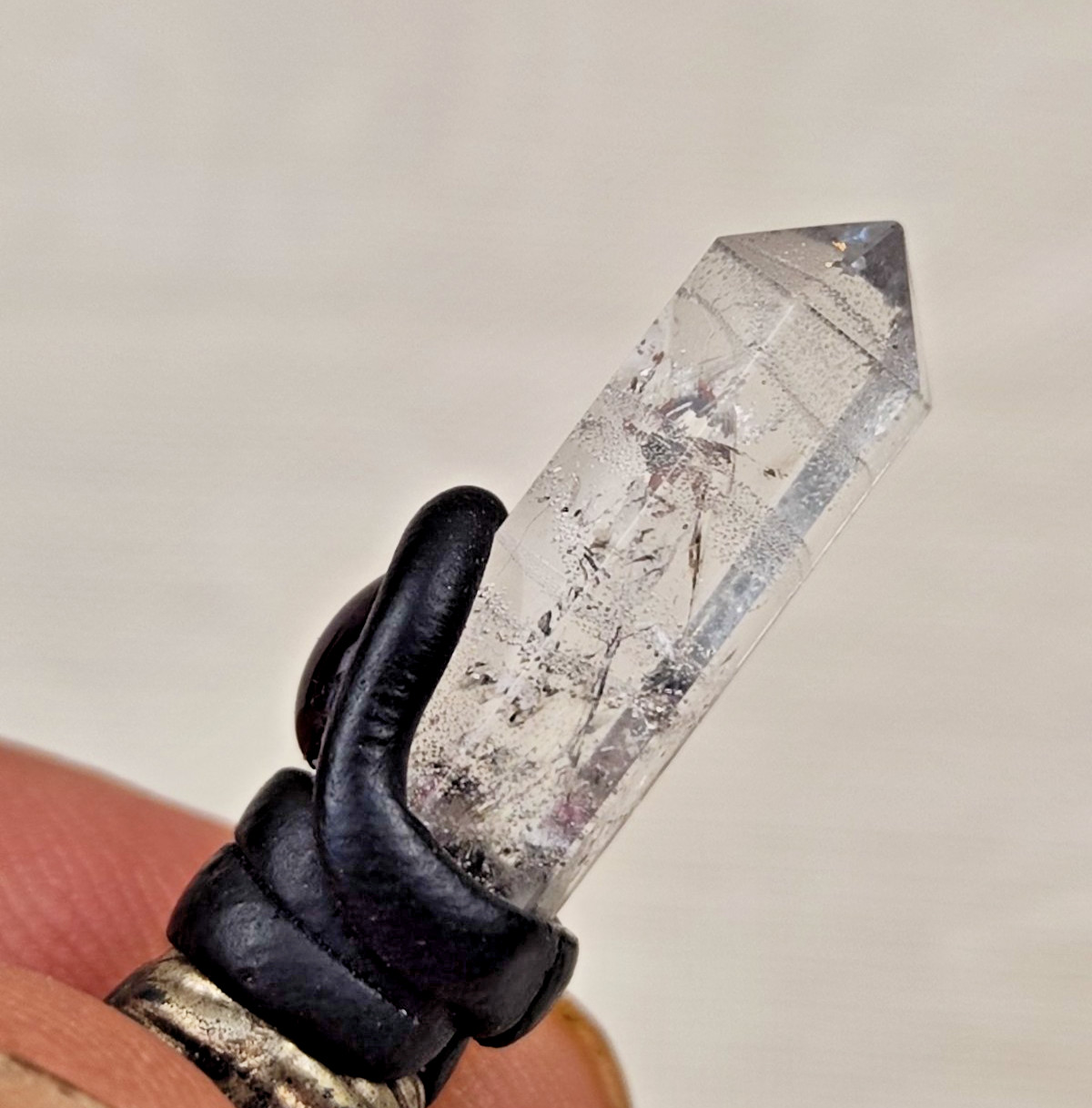 A pendant or talisman made of rock crystal and accented with a rose-red stone