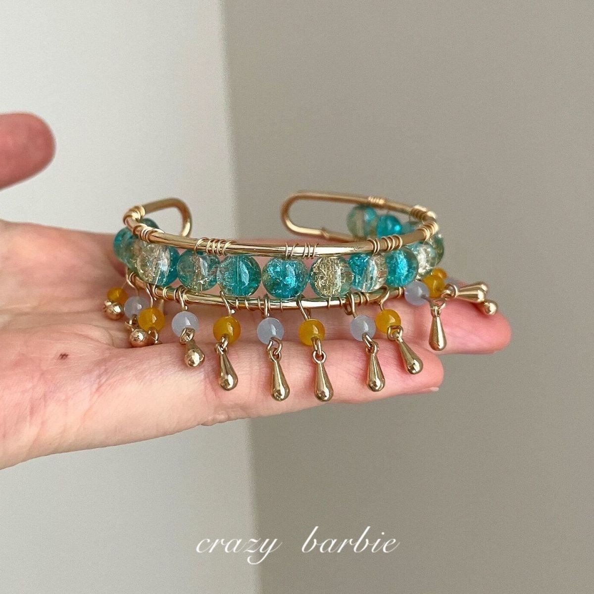 Green beaded bracelet with metal tassels