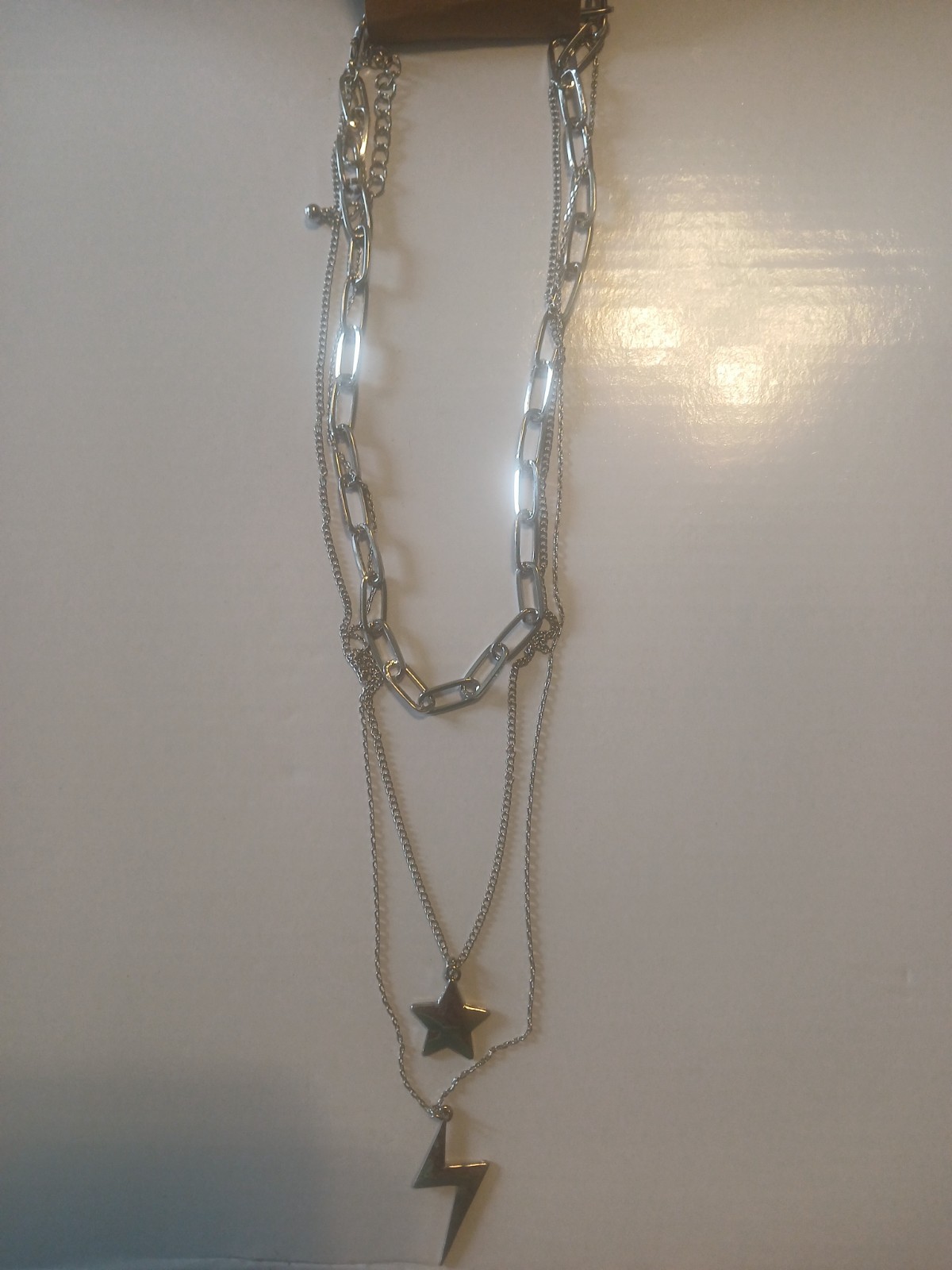 Ladies silver color fashion necklace. 3 chains, including 2 charms. Unknown bas