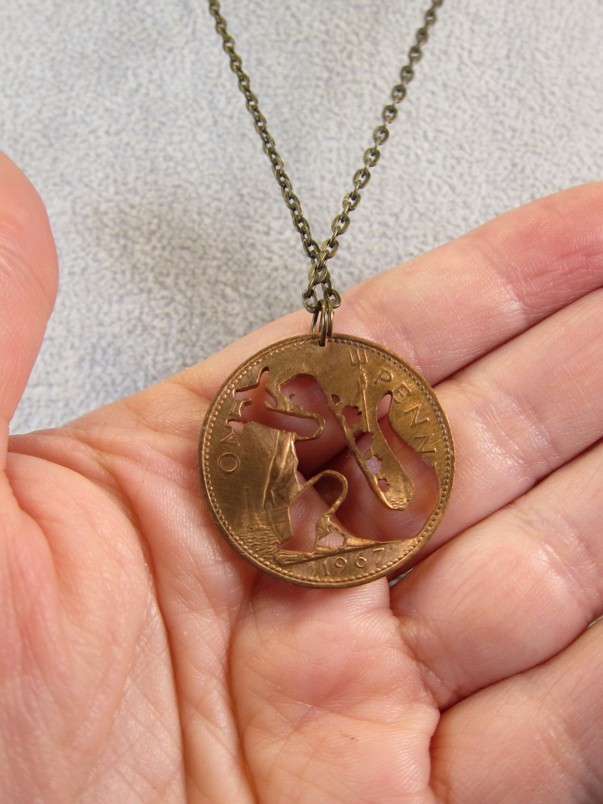 Cute 1967 British penny coin cutout necklace Godzilla grabbing airplane!