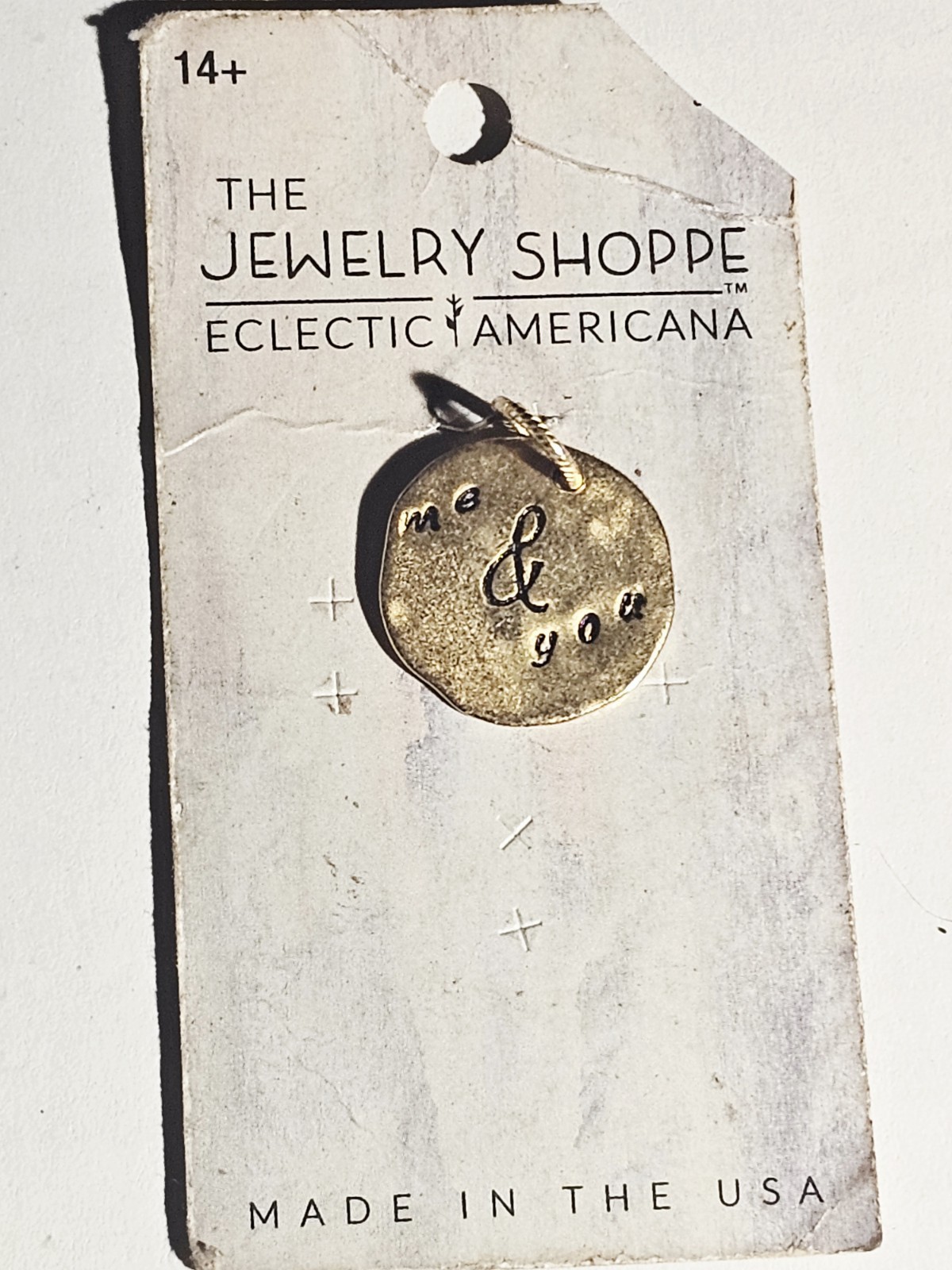 Eclectic Americana necklace features a gold-tone pendant stamped with the phrase